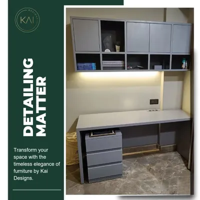 A complete home office setup we designed and installed, featuring a long grey desk, a matching mobile drawer unit, and overhead cabinets with both open and closed storage. The integrated under-cabinet lighting ensures a well-lit and productive workspace.