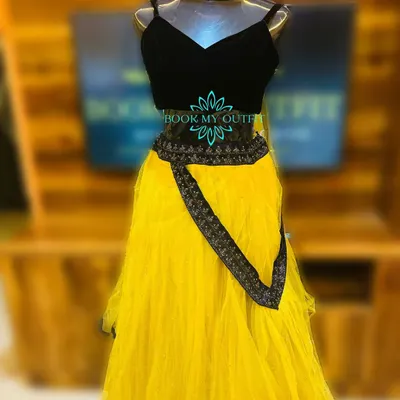 I have a special collection of outfits for Haldi ceremonies. This bright yellow net lehenga with a simple black blouse and embroidered belt is a popular rental choice for pre-wedding functions.