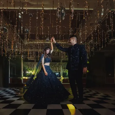 A fairytale first dance under a canopy of hanging lights on a checkered dance floor. We designed this setting to be pure magic.
