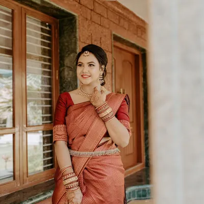 A beautiful portrait of a bride-to-be at her engagement. She is wearing a rich maroon saree, and her makeup is kept soft and radiant to celebrate the happy occasion.