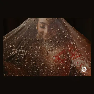 A creative and award-nominated bridal portrait, with the bride's face partially obscured by a pearl-studded veil that has the groom's name on it.