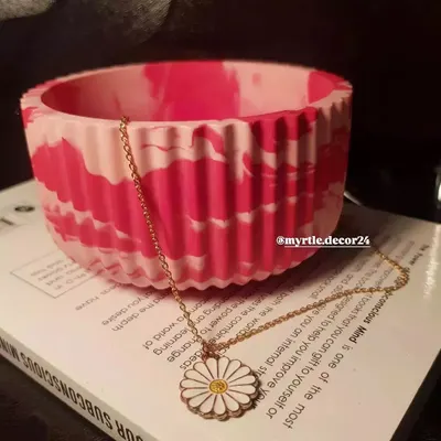This is our ribbed jar, shown here in a vibrant pink marble effect. We love how the vertical lines add texture and style. The jar is versatile and can be used as a candle holder, a small planter, or a pot for accessories.