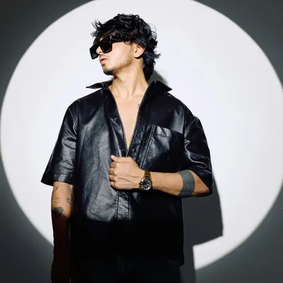 A shot from my 2025 press kit session. This look, with the leather shirt and sunglasses, captures my edgy and modern artist persona.