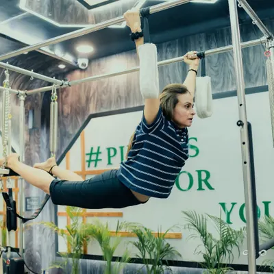 Defying gravity on the Trapeze Tower. This advanced exercise builds incredible upper body and core strength, requiring full-body integration and control.