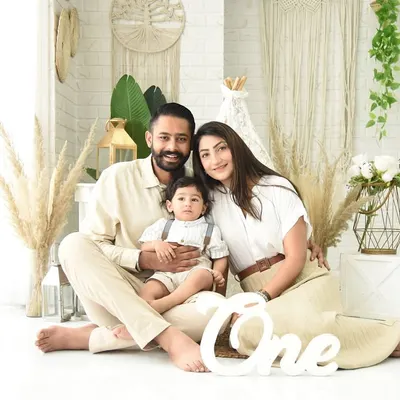 A first birthday family portrait in our popular boho studio setup. The "One" sign and coordinated neutral outfits mark this special milestone in a stylish and modern way.