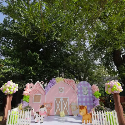 The complete pastel farmyard setup, nestled perfectly in a lush garden. We designed this entire scene, from the pink barn backdrop and picket fence to the whimsical balloon trees, creating a magical world for Nivedita's third birthday.