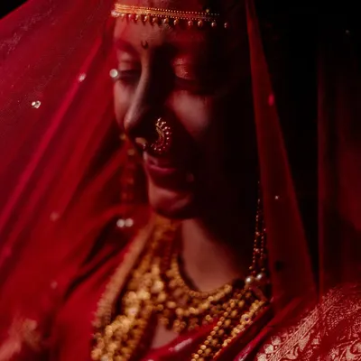 We believe a bridal portrait should be more than just a picture. It should be a feeling. Here, we used a traditional red veil and dramatic, low-key lighting to create a moment of quiet contemplation, transforming a simple portrait into a piece of timeless art.