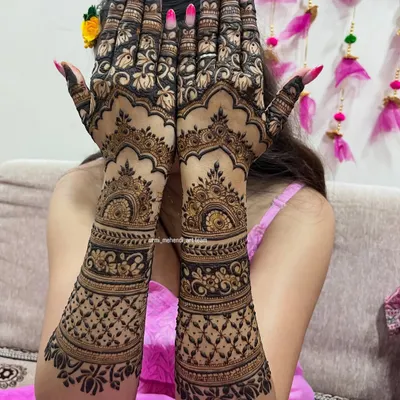 A full coverage back-hand design that is bold and beautiful. The contrast between the dark, filled-in floral patterns and the delicate net-like details creates a striking effect, perfect for a bride who wants to make a statement.