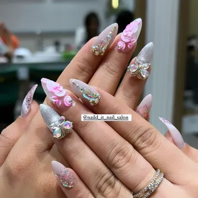 A showcase of our intricate 3D capabilities. This set features hand-sculpted pink acrylic flowers and sparkling butterfly charms made of Swarovski crystals on long stiletto extensions.