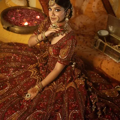 A breathtaking bridal look featuring a deep red lehenga with detailed paisley embroidery. This rental outfit comes with a full jewellery set, including the nath and maang tikka, for a complete and authentic bridal transformation.