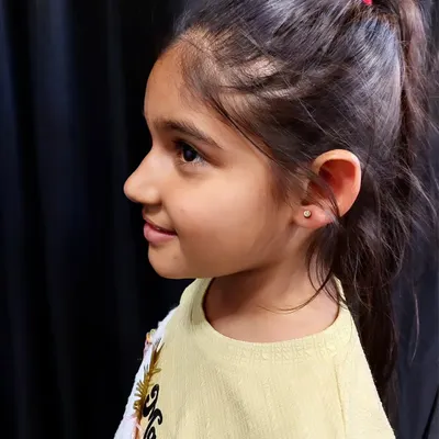A young client with her first earlobe piercing. I take extra care to ensure a gentle and positive experience for children.