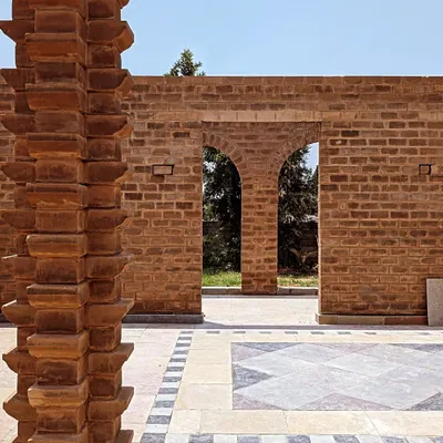 A view through brick archways into a beautifully tiled courtyard. This project showcases my work in creating durable and artistic hardscape structures that frame the garden and define outdoor rooms.
