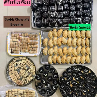 A festive dessert platter for Raksha Bandhan, featuring Double Chocolate Brownies, Shahi Gujiyas, Cookie Sticks, and Peanut Bites.