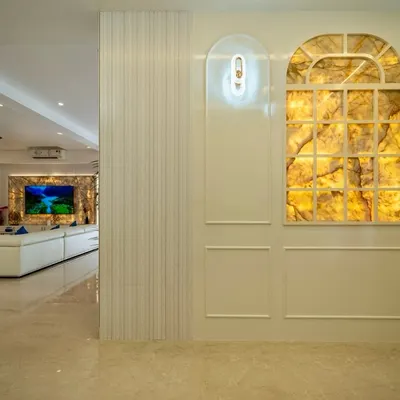This wall exudes luxury with its stunning backlit onyx panel, designed to look like a window. The warm, ambient glow highlights the stone's natural veins, creating a captivating focal point that is both artistic and elegant.