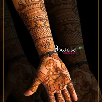 A beautiful dancing Ganesha figure on the palm, bringing blessings to the bride. Creating divine figures is a specialized skill I teach in my professional course.