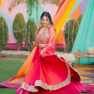 Twirling in a vibrant pink lehenga against a colorful Mehendi backdrop. This shot is all about capturing the festive energy of a wedding.