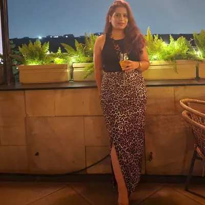 A full-length view of my Saturday night outfit. I paired a simple black top with a statement animal print maxi skirt with a side slit, creating a look that is both bold and sophisticated for a night out in Delhi.