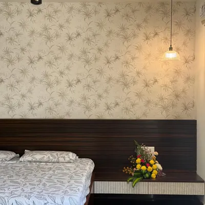 When your wallpaper whispers ‘calm,’ but your pendant screams ‘center of attention’. A lovely bedroom design balancing subtle patterns with a statement light.