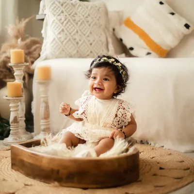 The sitting-up stage is full of personality. This happy 8-month-old is all smiles in my boho-themed studio setup, a perfect way to capture this exciting milestone.