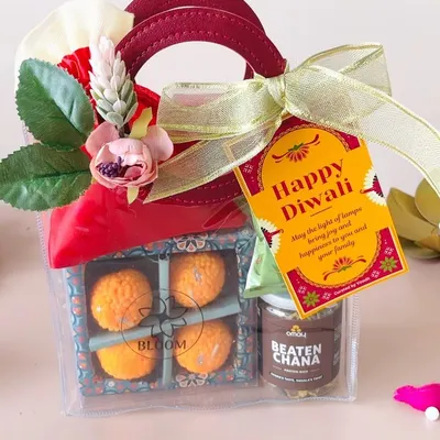 This transparent goodie bag is a fantastic budget-friendly option, containing laddoo candles and a jar of beaten chana, finished with a Happy Diwali tag.