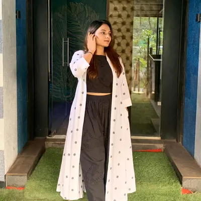 A chic and professional look featuring a custom-made co-ord set with a mul cotton jacket. The black crop top and pants are paired with a block-printed long jacket for a stylish statement.