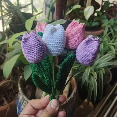 A beautiful handmade bouquet of crochet tulips in pastel shades of purple, pink, and white. These are perfect for a thoughtful gift that brings color into a room without any need for water.