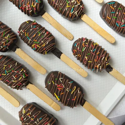 A tray of my classic chocolate cakesicles, drizzled with more chocolate and topped with rainbow sprinkles. They are the perfect party-sized treat.