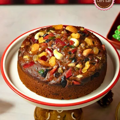 My signature Christmas Plum Cake, generously topped with candied fruits and nuts. This traditional cake is the centerpiece of any holiday celebration.