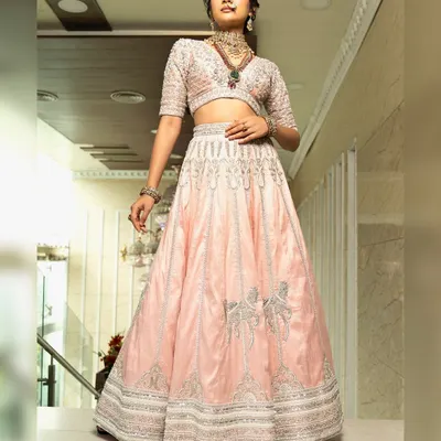 Twirl into a fairytale with this baby pink bridal lehenga. I designed it with intricate horse embroidery on the raw silk skirt and paired it with a heavily handworked blouse and a delicate net dupatta for a truly heavenly look.