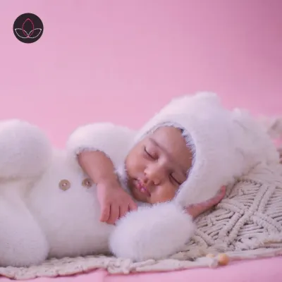 A dreamy and beautiful newborn portrait. This little one is dressed in a fluffy white bunny outfit, sleeping peacefully on a soft macrame pillow. These themed setups are a wonderful way to create truly magical first photos.