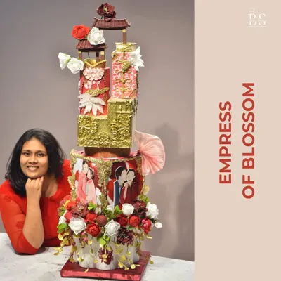 Here I am with the 'Empress of Blossom,' one of my most ambitious wedding cake projects. Standing tall, this cake combines marble textures, edible gold, and symbolic flowers to bless the couple with a loving and prosperous future.