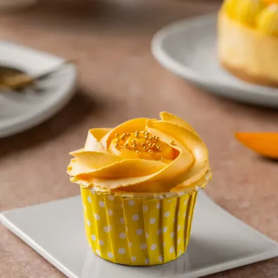 A golden swirl with a juicy thrill. Our Mango Cupcake is the perfect way to say hello to summer, with a surprise mango filling inside a light and fluffy cake.