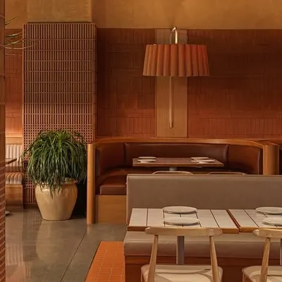 This wide view of Biergarten showcases how we used different seating arrangements, from booths to tables, to break up the large space. The consistent use of natural materials and warm lighting ties everything together into a cohesive, inviting environment.