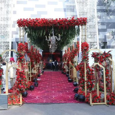 This grand entrance is the epitome of royal splendor. I designed a long walkway covered by a canopy of red roses and greenery, with crystal chandeliers hanging above a plush red carpet, creating an unforgettable welcome for a NESCO wedding.