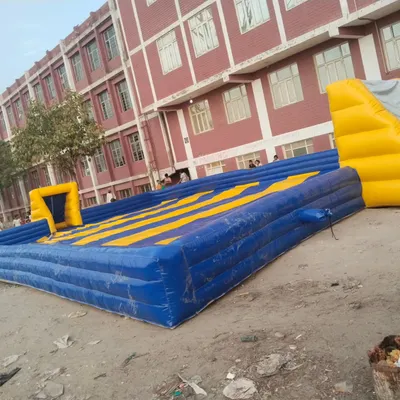 This is an inflatable soapy football court with a yellow and blue striped floor. It's a huge space, perfect for a 5-a-side game.