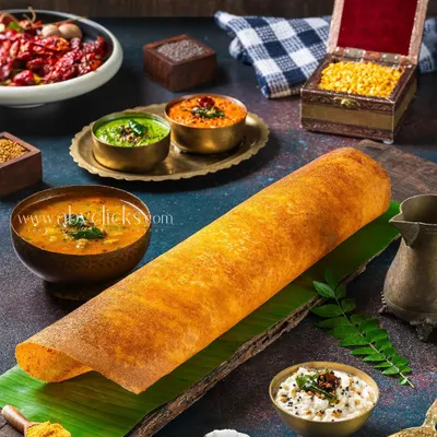 A classic Masala Dosa, styled with a variety of fresh ingredients and spices to create a rich, detailed foodscape. This shot emphasizes the authenticity and complexity of South Indian cooking.