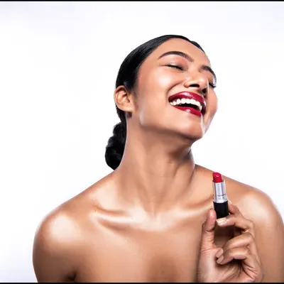 A perfect shot for a lipstick campaign, capturing a moment of pure joy. I directed the model to get this natural, happy expression while ensuring the product remained the hero. The high-key lighting setup keeps the focus on the vibrant color and the model's flawless application.