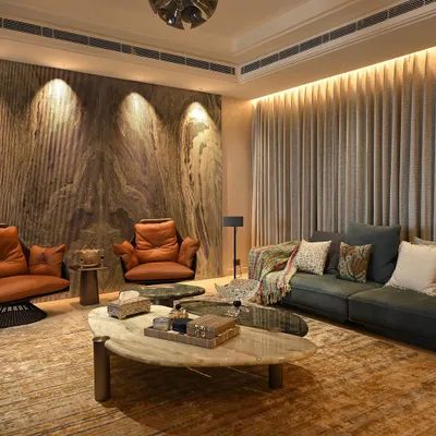 A look inside a recently completed project. The living room features dramatic accent lighting on a marble wall and automated curtains, creating a space that is both elegant and comfortable.
