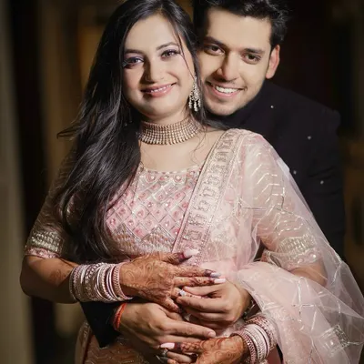 A warm, happy hug from behind. This portrait from an engagement shoot shows the couple's joy and comfort with each other. Her beautiful lehenga and his classic bandhgala are captured with a focus on their happy expressions.