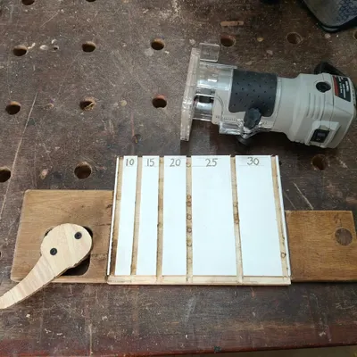 This is a cam-based clamping system I made for use with a router. I'm using it here with a V-bit to carve out slots for a nail sorting tray.