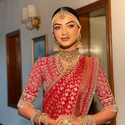 A complete South Indian bridal look featuring a sleek, center parted bun. The hairstyle is designed to perfectly accommodate the traditional matha patti and jhumkas, creating a regal and authentic bridal profile.