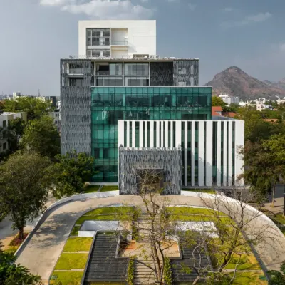 The Sona University Library is conceived as a vertical campus, with a striking facade of glass, stone, and jali screens. The design stacks diverse functions, from the library and auditorium to residential floors, creating a vibrant academic and cultural hub for the university.