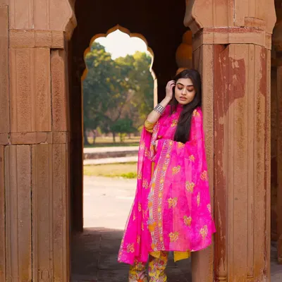 The vibrant pink of this suit creates a stunning contrast with the old stone architecture. I love mixing modern ethnic fashion with timeless backgrounds for a truly unique portrait.