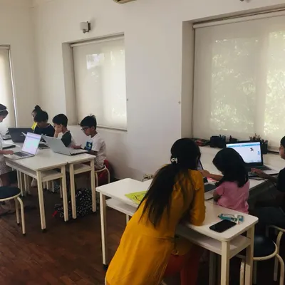 A view of our coding classroom where a mentor provides individual guidance to students as they work on their laptops. This shows our focus on personalized attention even in group settings to ensure every child understands the concepts.