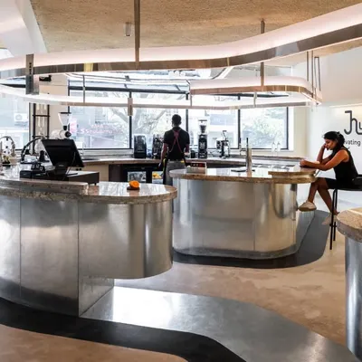 The central brew bar is the hero of the space, its form inspired by a coffee bean. It meanders through the cafe, guiding customers and creating pockets for seating and service.