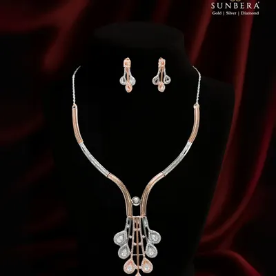 This stunning necklace set blends the cool shine of diamonds with the warm glow of rose gold. The modern, geometric pendant and matching earrings create a sophisticated look for any elegant evening.