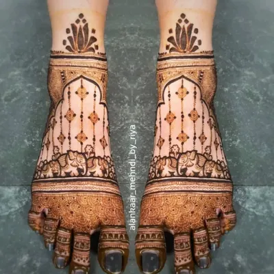 An elegant and symmetrical design for bridal feet, featuring hanging ornaments and elephant motifs within a traditional border.