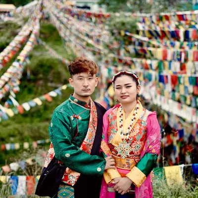 A classic portrait of a couple in traditional Kinnauri or Tibetan attire. The intricate details of their clothing and the direct gaze create a powerful and culturally rich image.