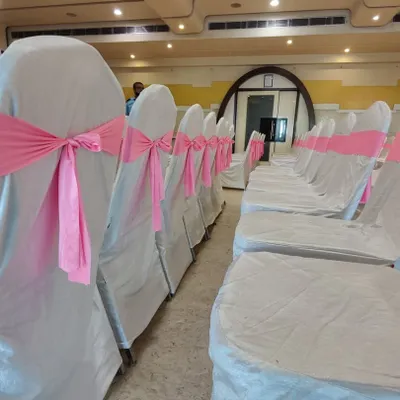 A close up of my chair decoration service for a baby shower. The chairs are fitted with clean white covers and tied with a beautiful pink sash, adding a touch of elegance to the seating arrangement.