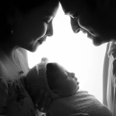 This is the moment it all begins. We use dramatic lighting to create this timeless silhouette portrait, focusing purely on the profound connection between new parents and their baby. It’s an artistic and emotional photograph that captures the love that fills the room.